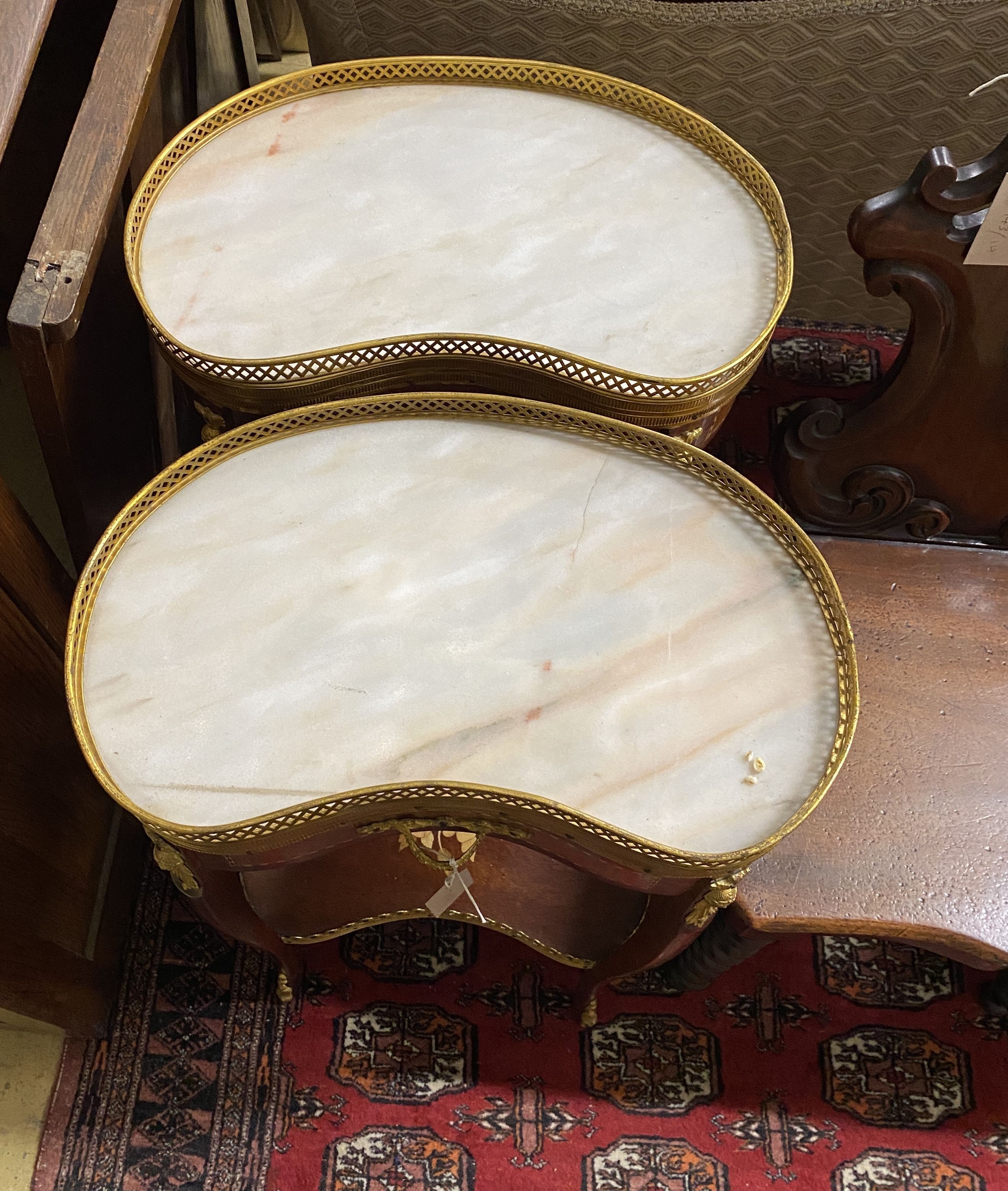 A pair of Louis XVI style marquetry inlaid marble topped kidney shaped bedside tables, width 44cm, depth 30cm, height 73cm